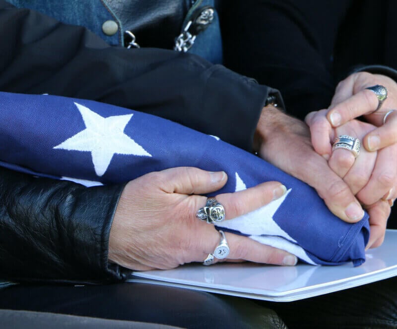 how to deal grieving and grief holding hands and folded american flag given them at their fathers funeral sad death