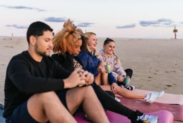 Young adults watching a serene sunset on the beach after dual diagnosis rehab at Refresh Recovery in San Diego