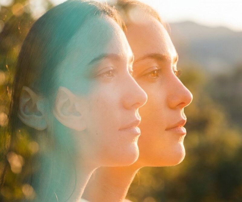 Double-exposure portrait symbolizing dual diagnosis, with overlapping profiles in teal and orange light