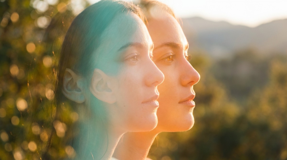 Double-exposure portrait symbolizing dual diagnosis, with overlapping profiles in teal and orange light