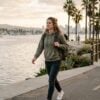 Young woman with a backpack walking the Mission Bay boardwalk in San Diego on her way to outpatient treatment