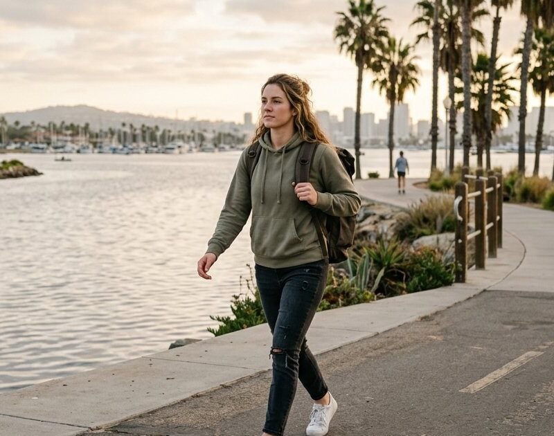 Young woman with a backpack walking the Mission Bay boardwalk in San Diego on her way to outpatient treatment